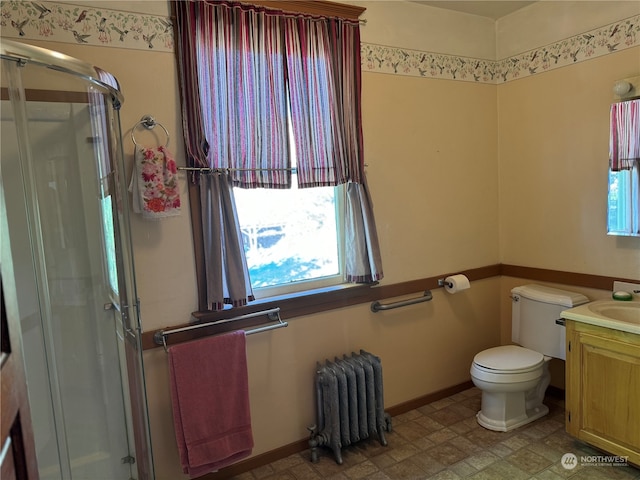 bathroom featuring radiator heating unit, a shower with door, vanity, and a healthy amount of sunlight