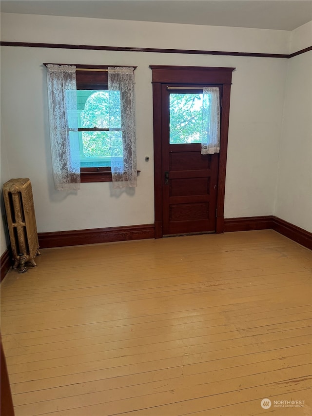 entrance foyer with light wood-type flooring and radiator