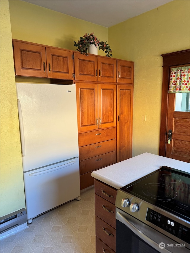 kitchen featuring white refrigerator and stainless steel electric range oven