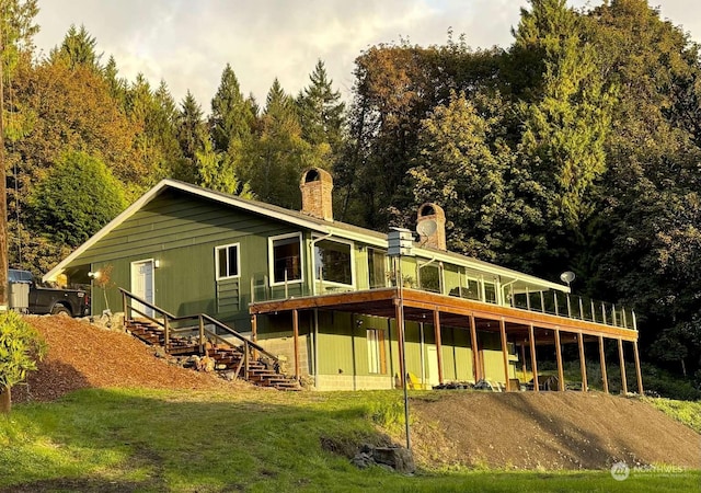 back of house featuring a lawn and a wooden deck