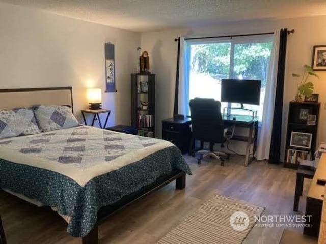 bedroom featuring wood-type flooring and a textured ceiling