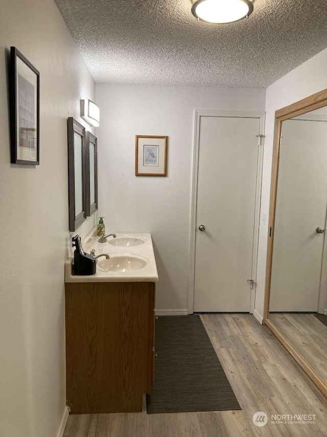 bathroom featuring vanity, a textured ceiling, and hardwood / wood-style flooring