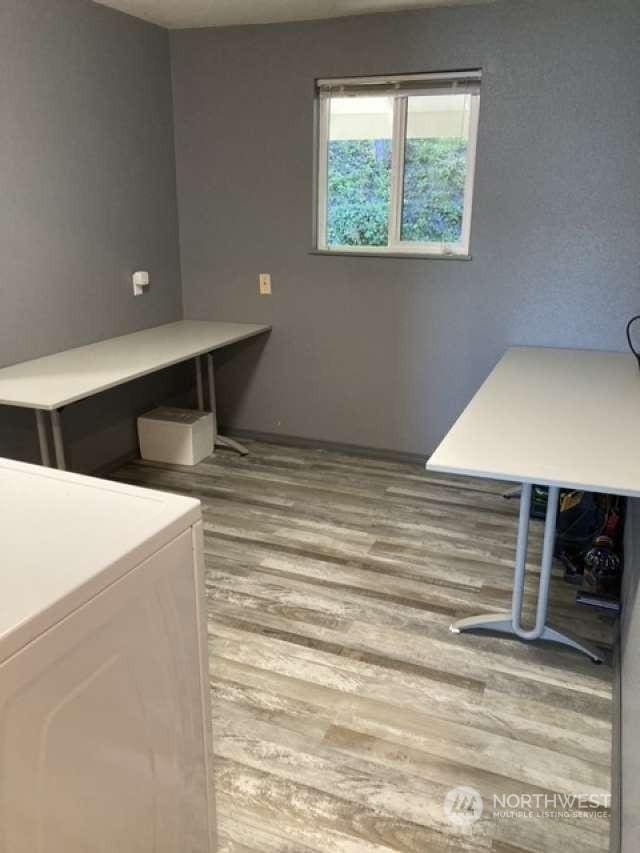 laundry area featuring wood-type flooring and washer / dryer