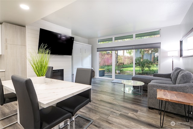 dining area featuring wood walls and dark hardwood / wood-style flooring