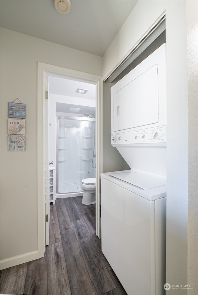 clothes washing area featuring stacked washer / dryer and dark hardwood / wood-style flooring