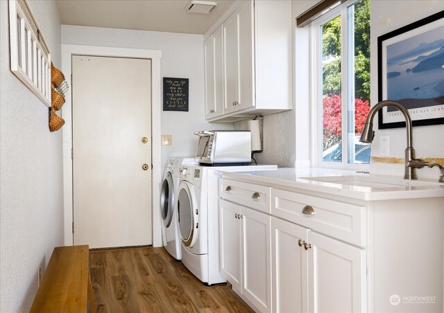 washroom with cabinets, dark hardwood / wood-style floors, sink, and washing machine and clothes dryer