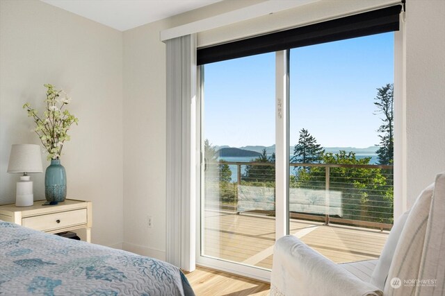 bedroom featuring a water view and light wood-type flooring