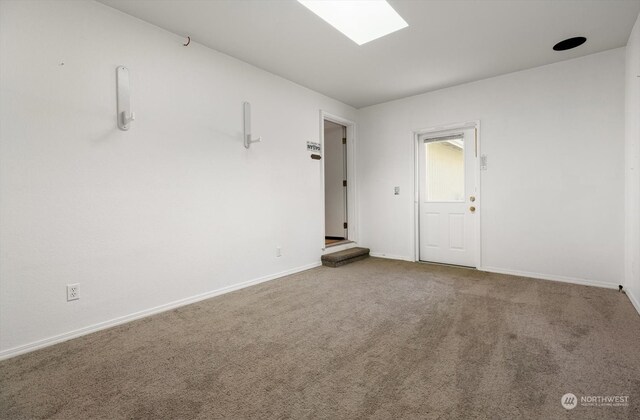 carpeted spare room with a skylight