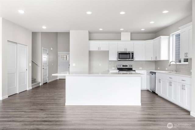 14727 88th Way SE Unit 18, Yelm, WA 98597 - kitchen with a sink, white cabinets, backsplash, appliances with stainless steel finishes, and a kitchen island