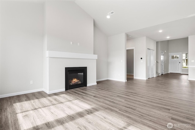 14727 88th Way SE Unit 18, Yelm, WA 98597 - unfurnished living room featuring wood finished floors, visible vents, baseboards, a glass covered fireplace, and recessed lighting