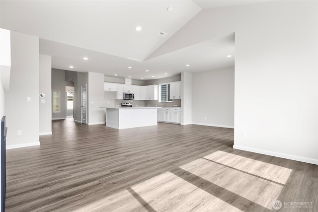 14727 88th Way SE Unit 18, Yelm, WA 98597 - unfurnished living room featuring baseboards, wood finished floors, recessed lighting, and vaulted ceiling