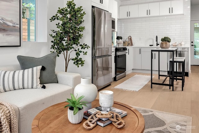 living room featuring light wood-type flooring and sink