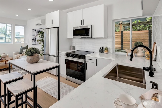 kitchen with stainless steel appliances, tasteful backsplash, sink, and a healthy amount of sunlight