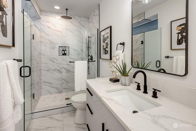 bathroom featuring toilet, a shower with door, and vanity