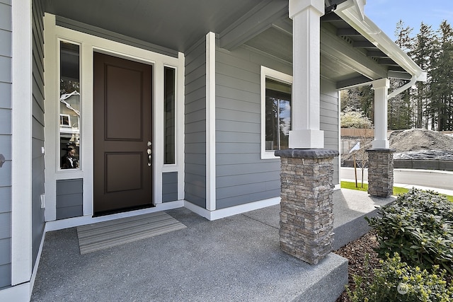 view of exterior entry featuring covered porch