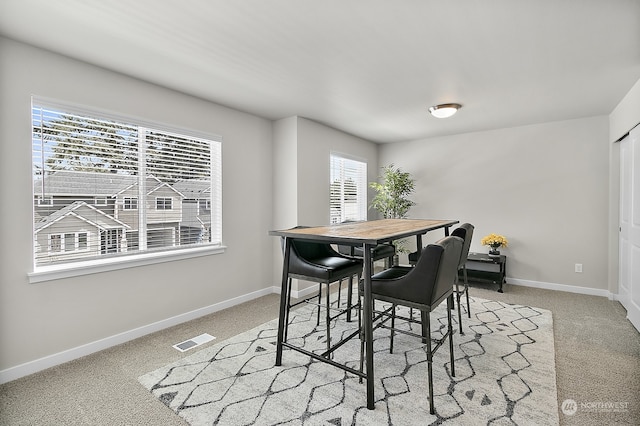 dining space with light colored carpet