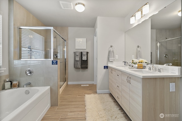 bathroom featuring vanity, separate shower and tub, and wood-type flooring