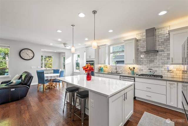 kitchen featuring dark hardwood / wood-style floors, decorative light fixtures, a kitchen island, and white cabinetry