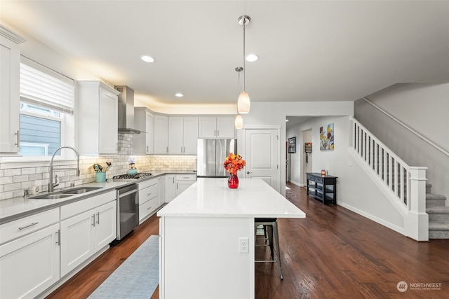 kitchen featuring stainless steel appliances, decorative light fixtures, dark hardwood / wood-style flooring, and a center island