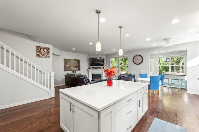 kitchen featuring hanging light fixtures, dark hardwood / wood-style floors, white cabinets, and a healthy amount of sunlight