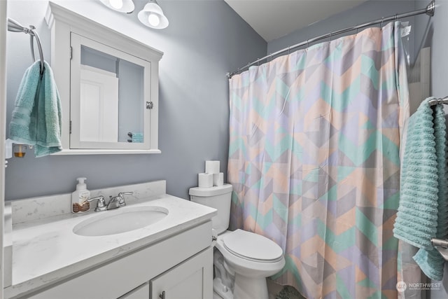 bathroom featuring curtained shower, vanity, and toilet