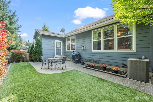 back of property with a yard, a patio, and central air condition unit