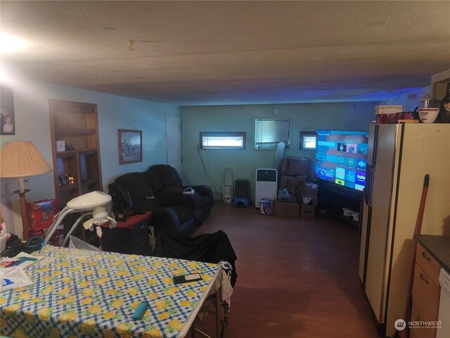 bedroom with freestanding refrigerator and wood finished floors
