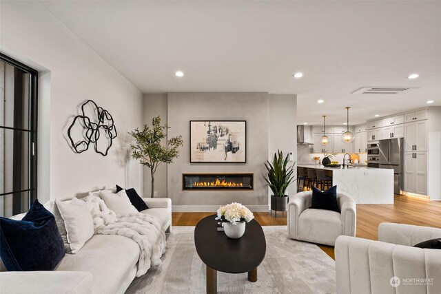 living room with sink and light hardwood / wood-style flooring