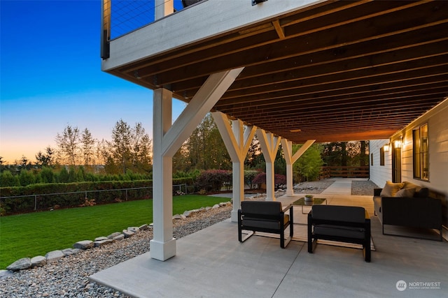 patio terrace at dusk with an outdoor hangout area and a yard