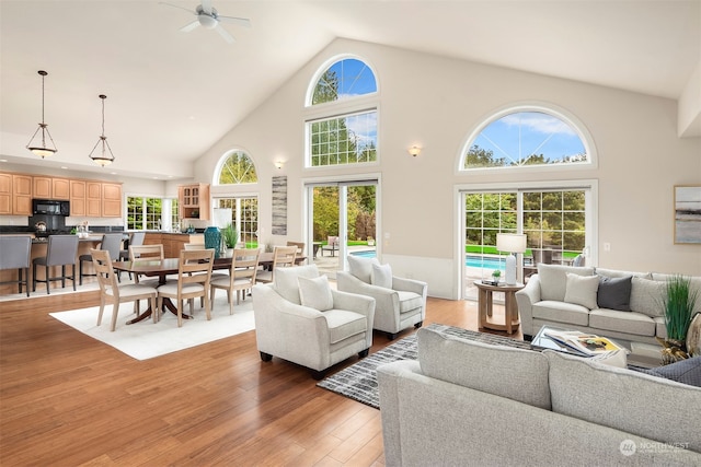 living room featuring high vaulted ceiling, ceiling fan, and hardwood / wood-style flooring