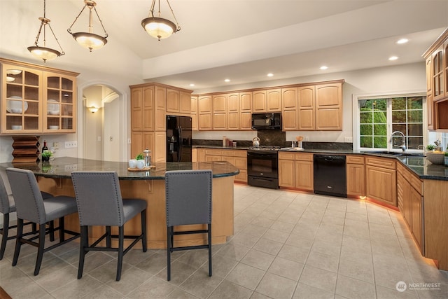 kitchen featuring hanging light fixtures, black appliances, lofted ceiling, a kitchen bar, and sink