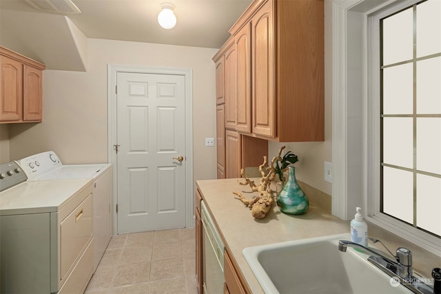 laundry area with washing machine and dryer, sink, light tile patterned floors, and cabinets