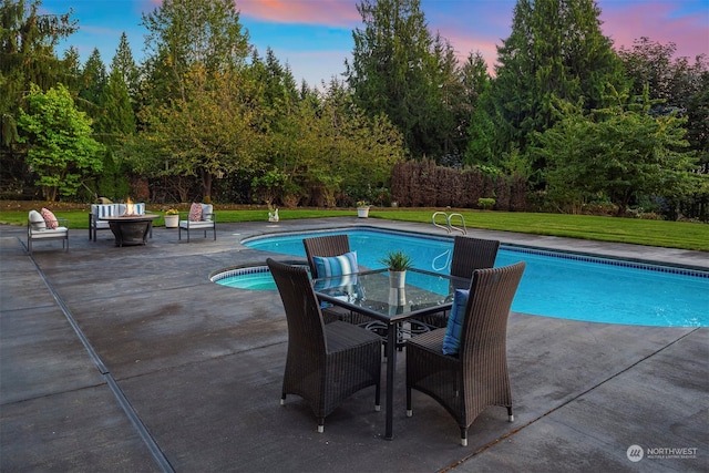 pool at dusk with a patio and a yard