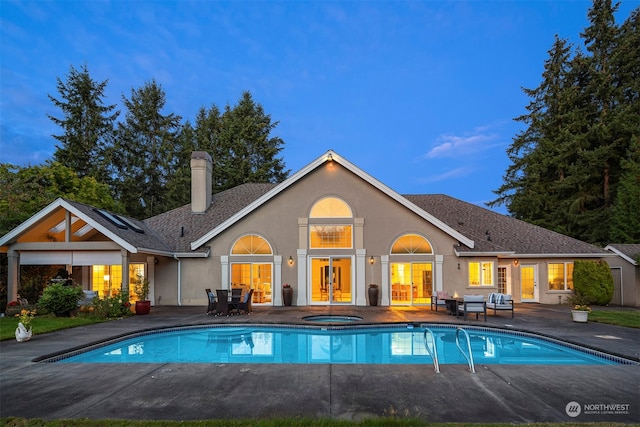 back house at dusk with a patio area and french doors