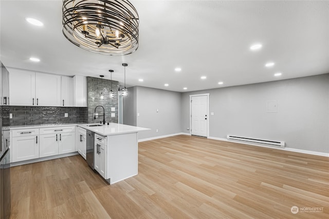 kitchen featuring light wood-type flooring, stainless steel dishwasher, kitchen peninsula, white cabinetry, and a baseboard radiator