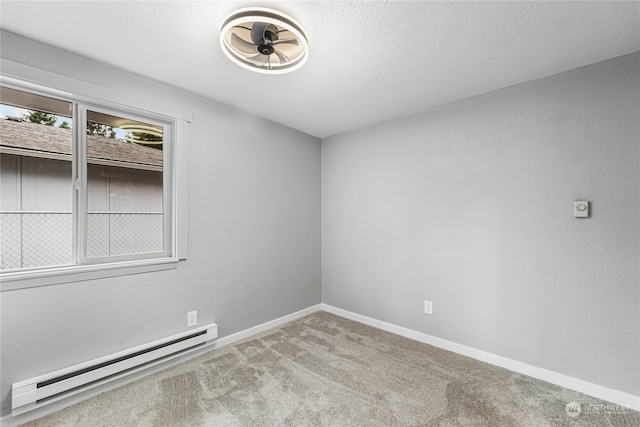 unfurnished room with carpet flooring, a baseboard heating unit, and a textured ceiling