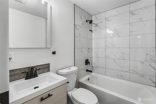 full bathroom featuring toilet, vanity, tiled shower / bath, and a textured ceiling