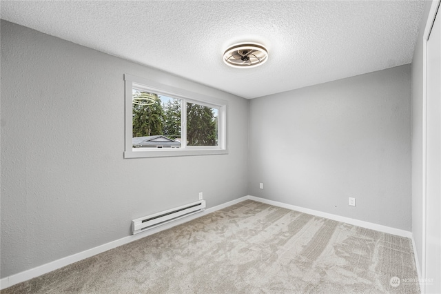 carpeted empty room featuring a textured ceiling and a baseboard heating unit