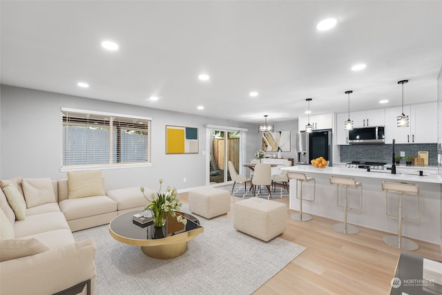 living room with light wood-type flooring and a notable chandelier