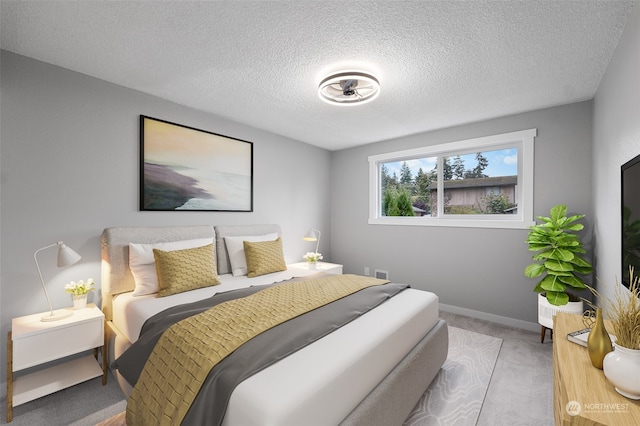 bedroom featuring light colored carpet and a textured ceiling