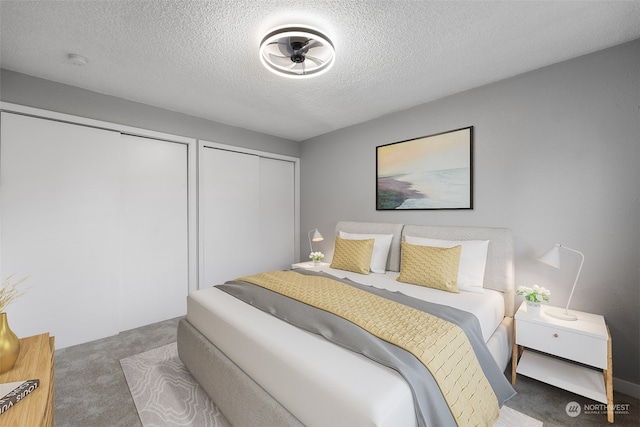 bedroom with multiple closets, carpet, and a textured ceiling