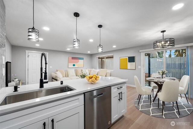 kitchen featuring pendant lighting, sink, white cabinets, and dishwasher