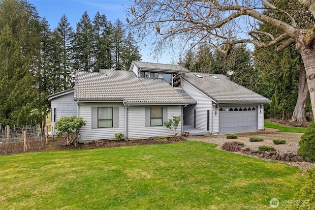 view of front of property with fence, a front lawn, an attached garage, and a tiled roof