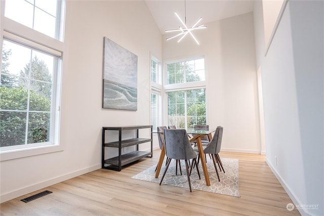 dining area featuring light hardwood / wood-style flooring, high vaulted ceiling, and a healthy amount of sunlight