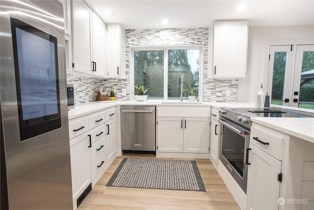 kitchen with white cabinets, a healthy amount of sunlight, and appliances with stainless steel finishes