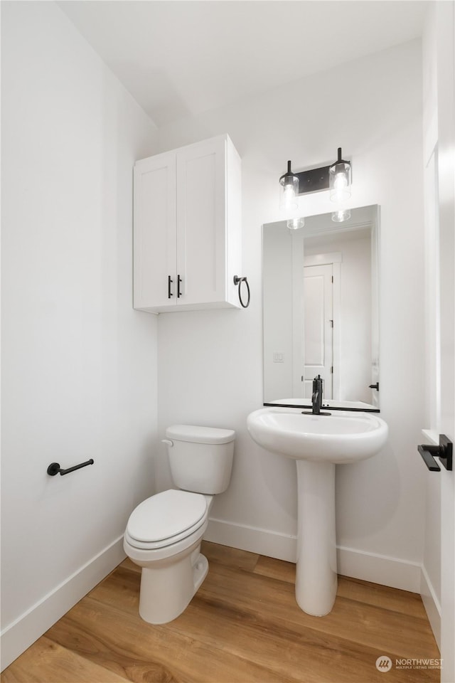 bathroom with hardwood / wood-style floors and toilet