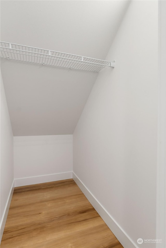 spacious closet with wood-type flooring and vaulted ceiling