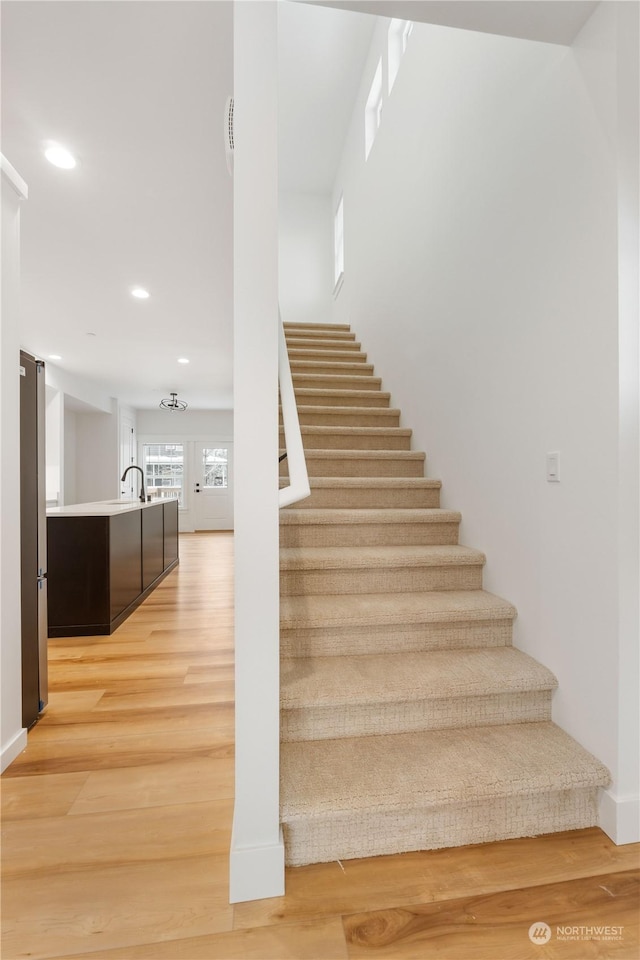 stairway featuring sink and hardwood / wood-style flooring