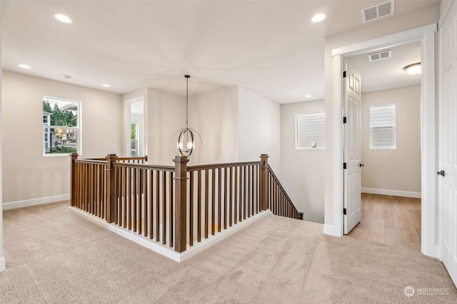 hallway featuring a notable chandelier and light hardwood / wood-style floors