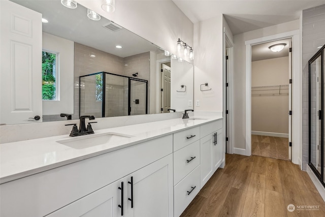 bathroom with vanity, walk in shower, and wood-type flooring